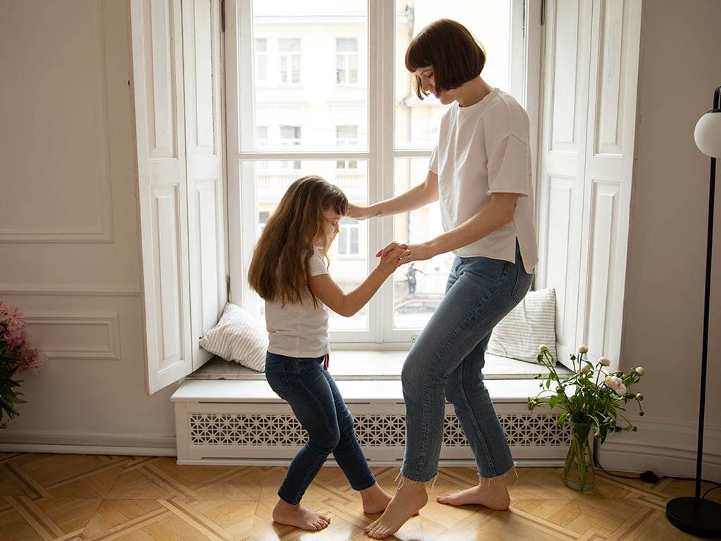 Niña bailando con su madre