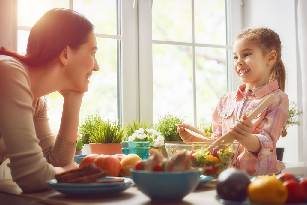 Madre e hija preparando una ensalada juntas